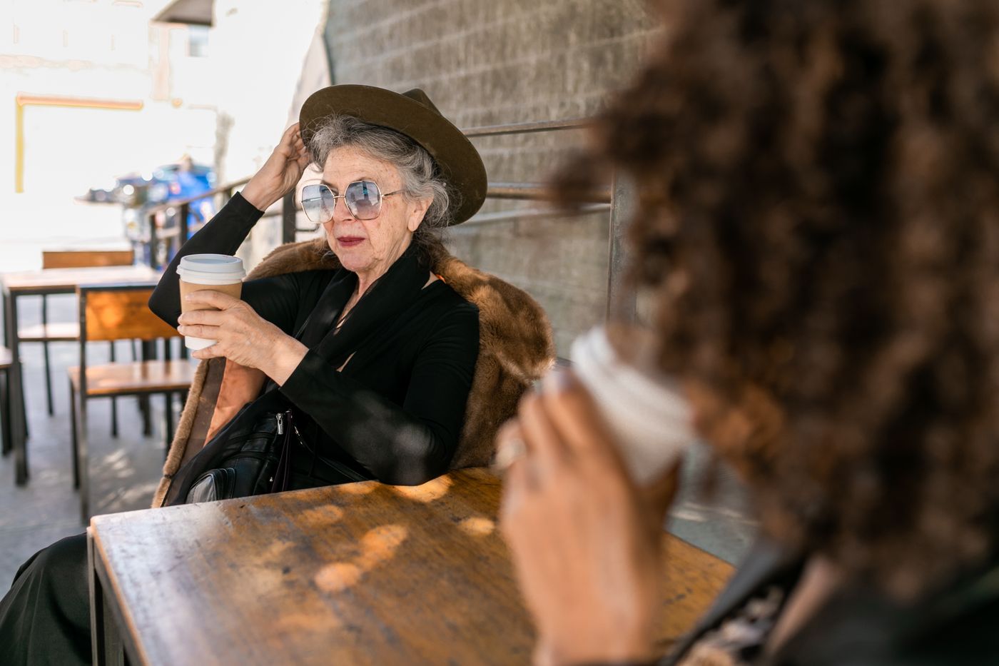 Two women in conversation across a table in a cafe